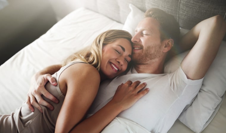 man and woman in bed, laughing about childrens books about how babies are made