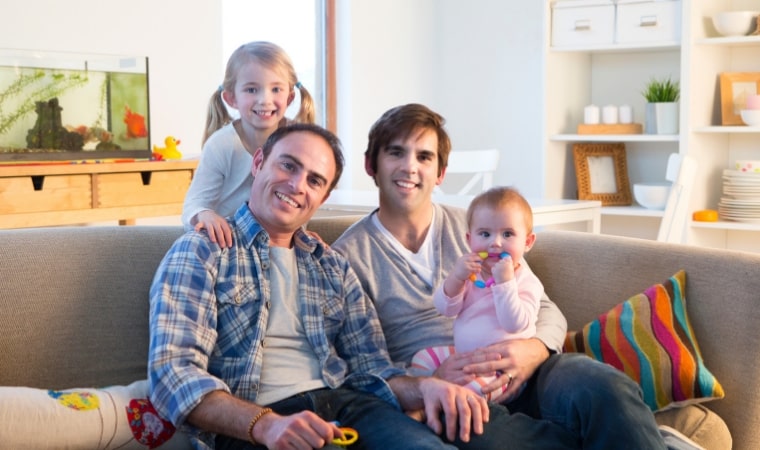 same sex LGBT family on couch reading childrens books