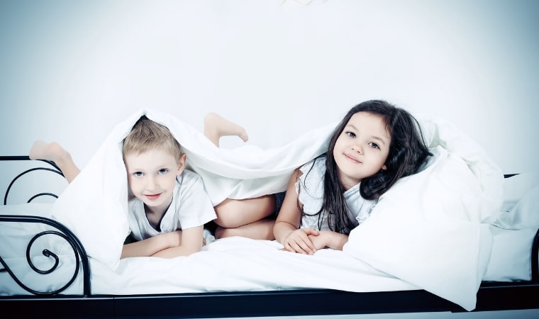 2 children playing in a bed for a teachable moment