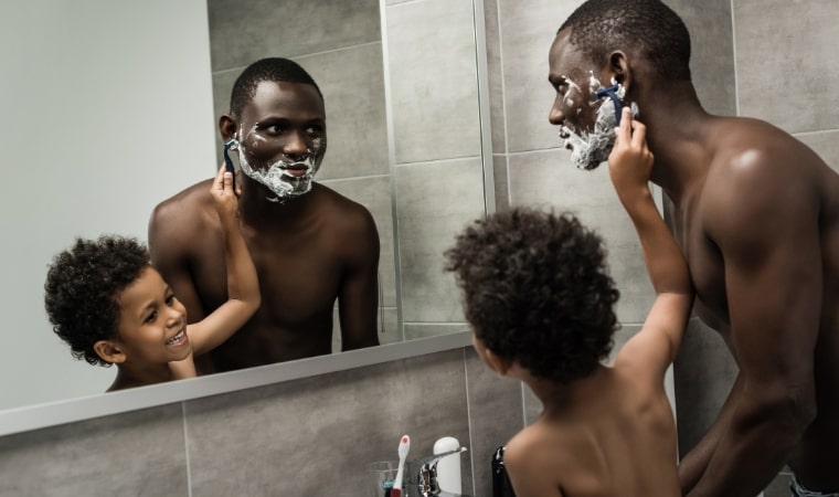 father teaching son to shave