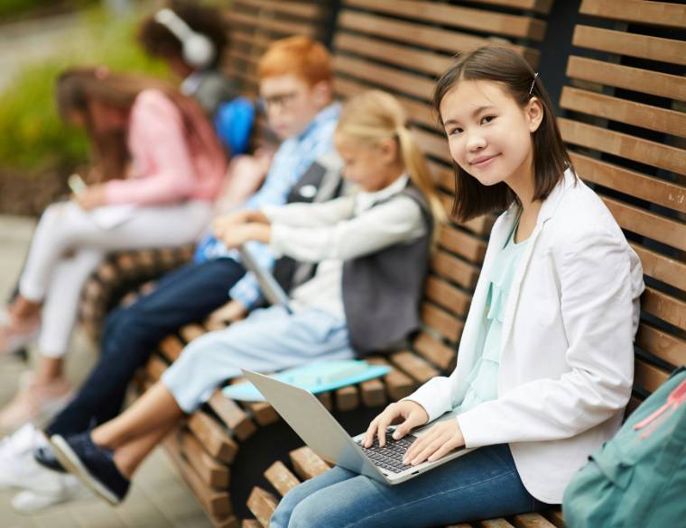 ten year olds sitting on a bench looking at puberty books