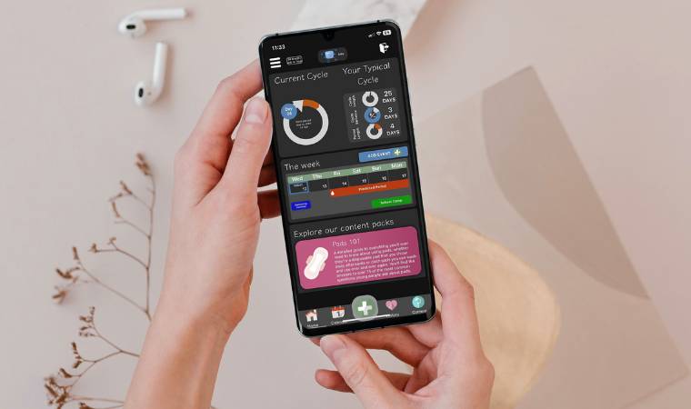 TEMPUS period tracker app on a phone held in two hands