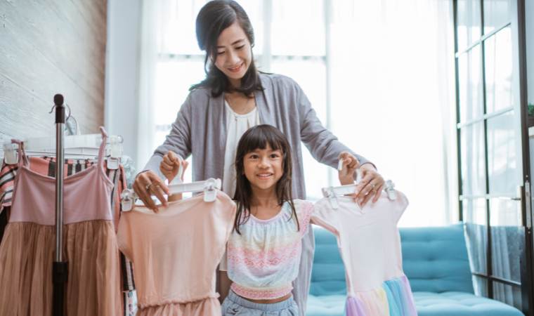 mother helping child to choose clothes that are modest and work for their family values