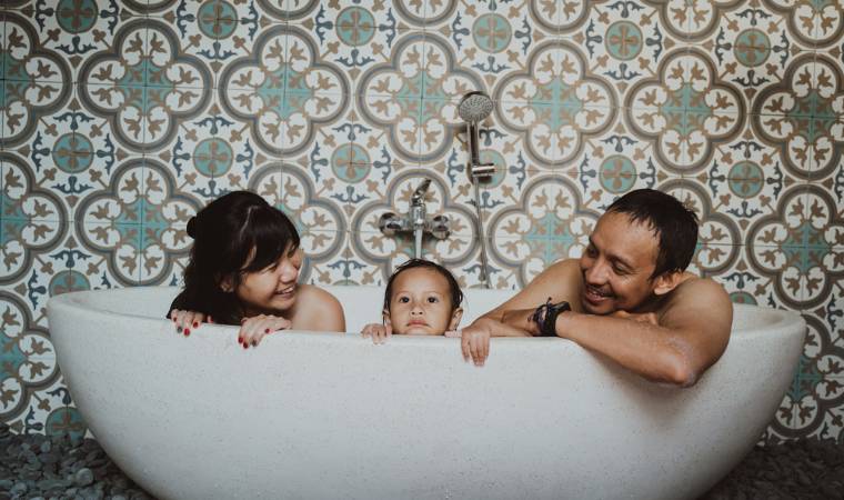 mother, father and child naked in the family bathtub together