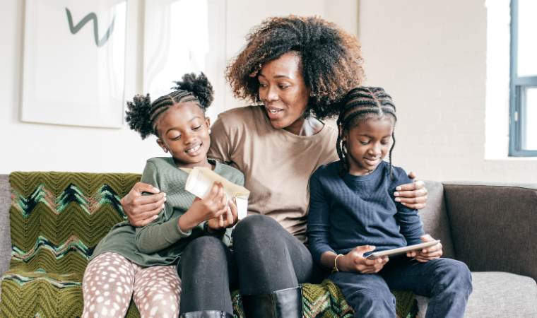 mother talking with her two children about online safety as they play on cell phones
