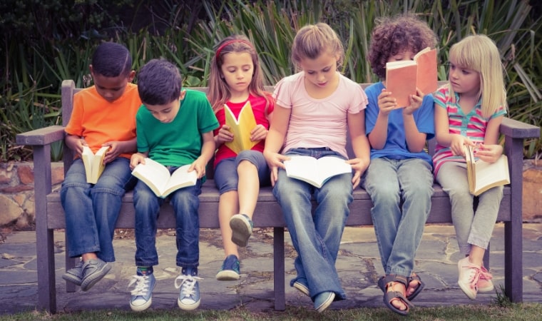 children sitting on a bench reading sex education books for 8 year olds